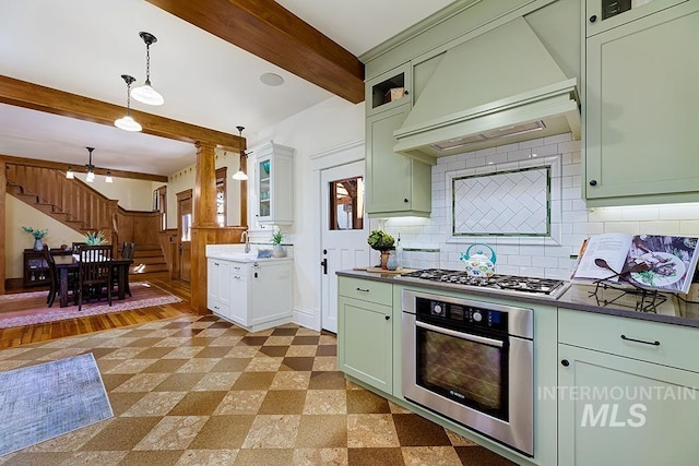 kitchen with pendant lighting, appliances with stainless steel finishes, beam ceiling, green cabinetry, and custom exhaust hood