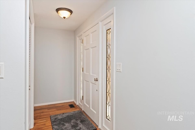 entryway featuring baseboards and wood finished floors