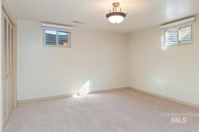 basement with visible vents, baseboards, and carpet floors