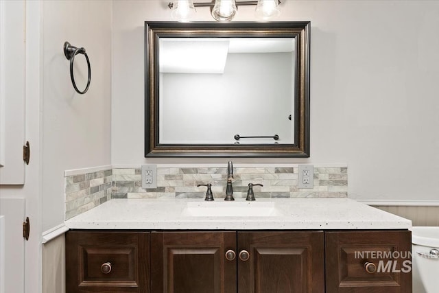 bathroom featuring vanity and tasteful backsplash