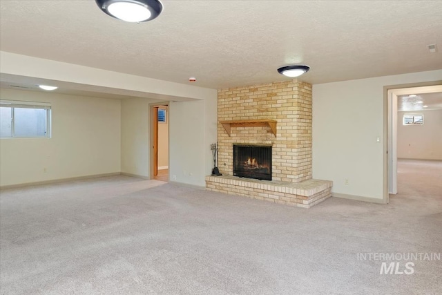 unfurnished living room featuring a brick fireplace, carpet flooring, baseboards, and a textured ceiling