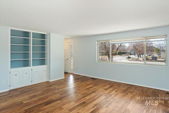 empty room featuring wood finished floors and baseboards