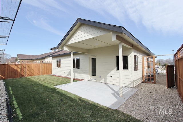 rear view of property with a patio and a lawn