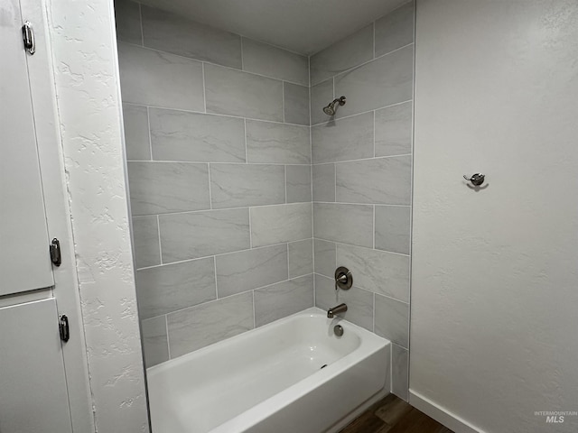 full bath featuring a textured wall and shower / washtub combination