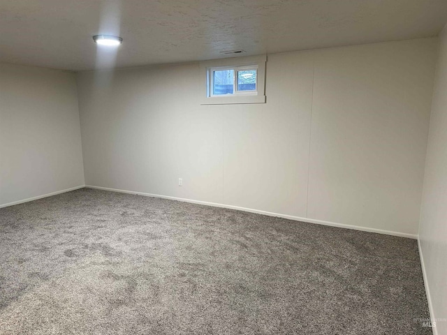 below grade area featuring carpet flooring, baseboards, and a textured ceiling