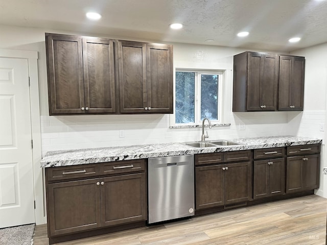 kitchen featuring a sink, light wood-type flooring, stainless steel dishwasher, and dark brown cabinetry