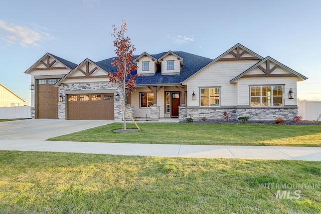 view of front of house featuring stone siding, a front lawn, concrete driveway, and an attached garage