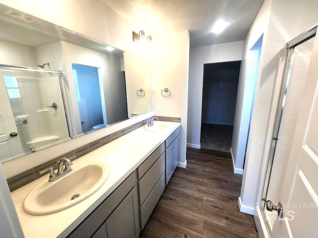 bathroom featuring backsplash, an enclosed shower, toilet, vanity, and hardwood / wood-style flooring