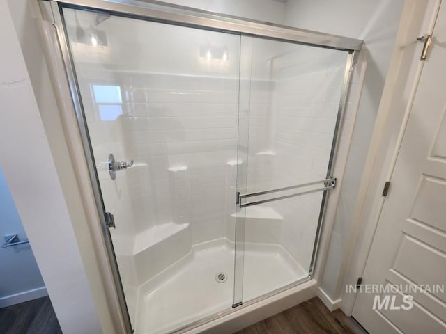 bathroom featuring wood-type flooring and an enclosed shower