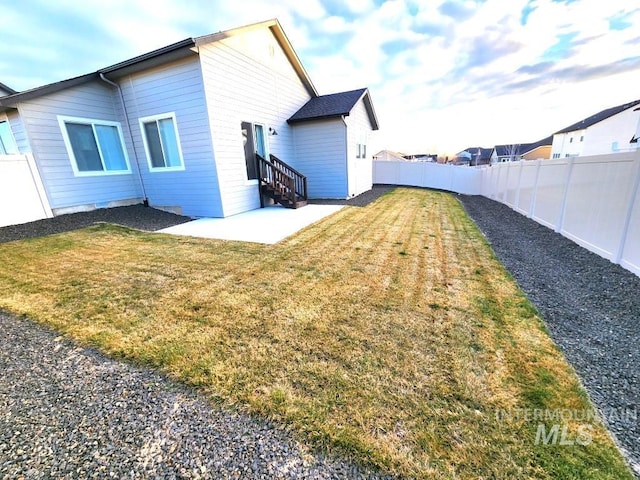 rear view of house with a yard and a patio