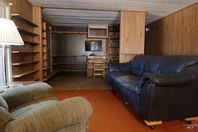 living room with wood walls and dark colored carpet