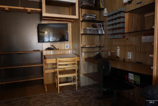 carpeted home office featuring wooden walls