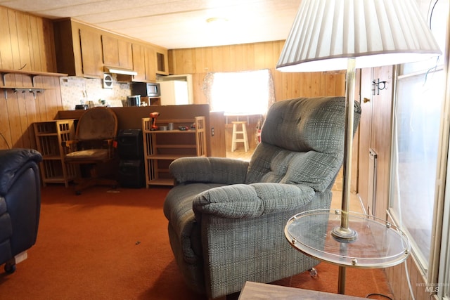 carpeted living room featuring wood walls