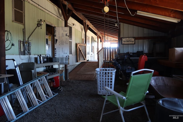 miscellaneous room with lofted ceiling, wood walls, and carpet flooring