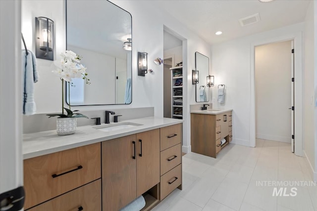 bathroom featuring two vanities, a sink, visible vents, and recessed lighting