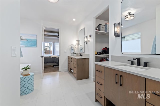 full bathroom featuring ensuite bathroom, two vanities, a sink, and recessed lighting