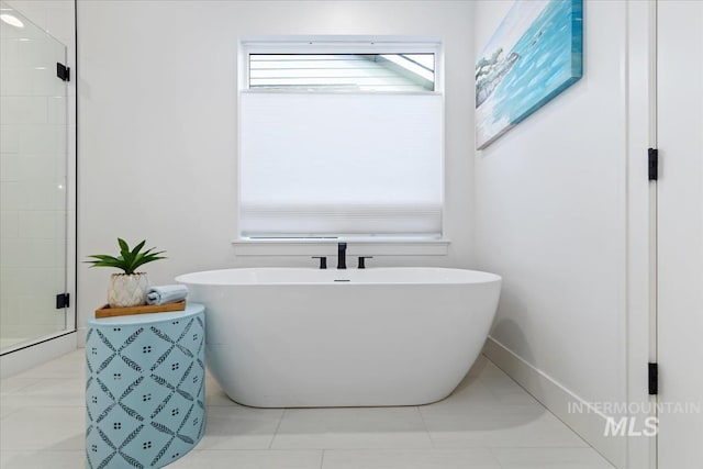 bathroom with a soaking tub, a shower stall, and tile patterned floors