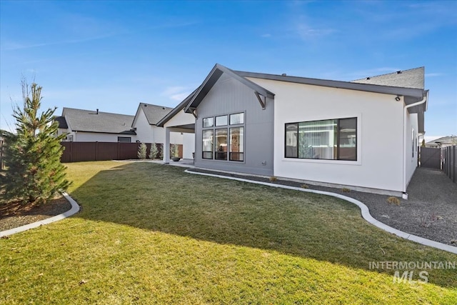 rear view of property featuring stucco siding, a fenced backyard, a patio, and a yard