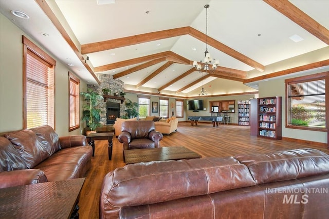 living area featuring beam ceiling, a fireplace, high vaulted ceiling, wood finished floors, and a chandelier