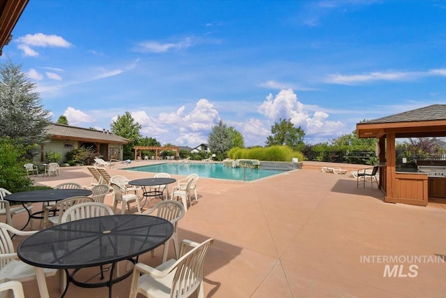 pool featuring a patio area, a grill, and outdoor dining space