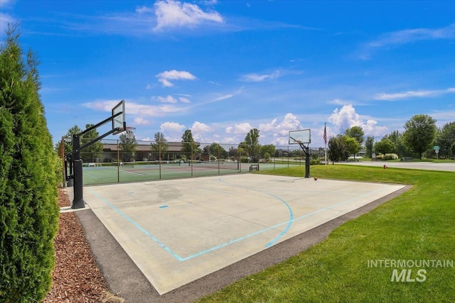 view of basketball court featuring community basketball court, fence, and a lawn