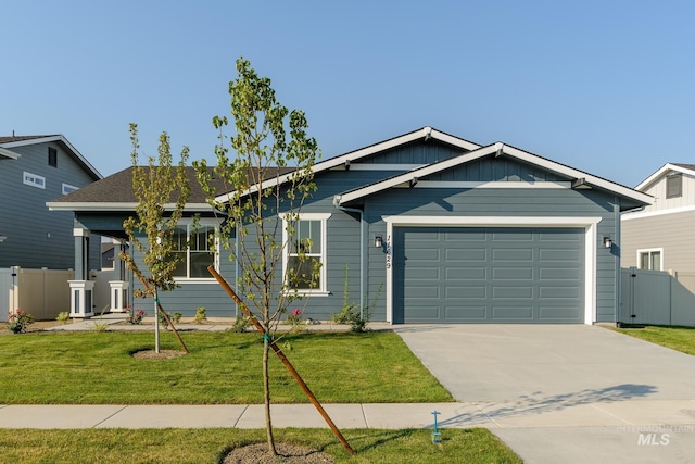 ranch-style house with fence, a front lawn, concrete driveway, a garage, and board and batten siding