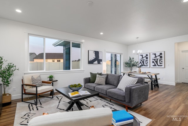 living area featuring recessed lighting, baseboards, an inviting chandelier, and wood finished floors