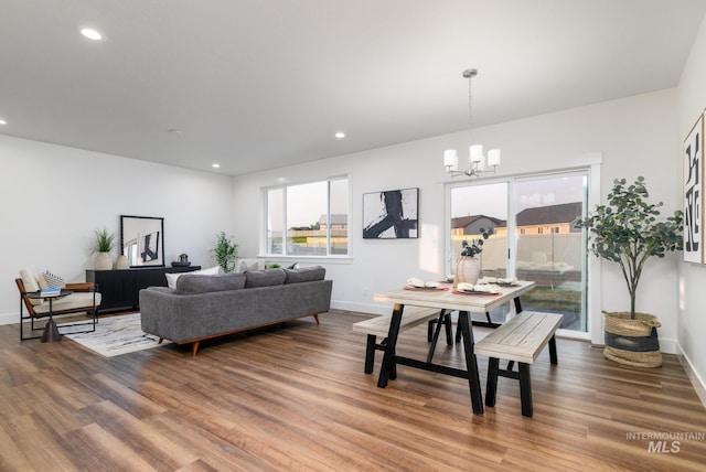 living room featuring recessed lighting, baseboards, a notable chandelier, and wood finished floors