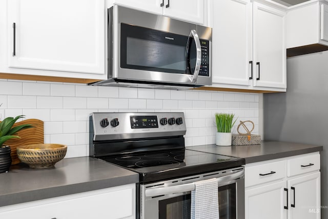 19920 Lenape Ct, Caldwell, ID 83605 - kitchen featuring stainless steel appliances, dark countertops, white cabinets, and decorative backsplash