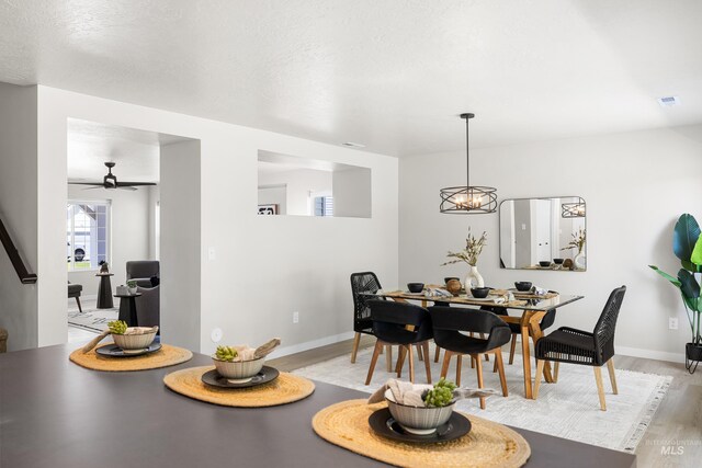 19920 Lenape Ct, Caldwell, ID 83605 - dining space featuring light wood finished floors, a ceiling fan, baseboards, and a chandelier