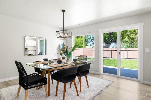19920 Lenape Ct, Caldwell, ID 83605 - dining room featuring a chandelier, light wood-style flooring, and baseboards