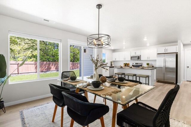 19920 Lenape Ct, Caldwell, ID 83605 - dining room featuring light wood-type flooring, baseboards, a chandelier, and recessed lighting