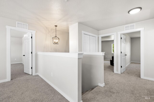 19920 Lenape Ct, Caldwell, ID 83605 - hallway featuring an upstairs landing, carpet, baseboards, and a chandelier