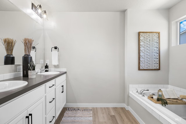 19920 Lenape Ct, Caldwell, ID 83605 - full bathroom featuring double vanity, wood finished floors, a garden tub, and baseboards