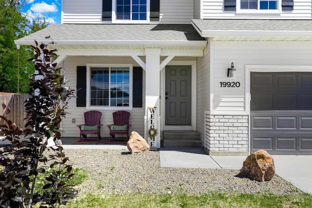 19920 Lenape Ct, Caldwell, ID 83605 - doorway to property featuring a porch, a shingled roof, and a garage