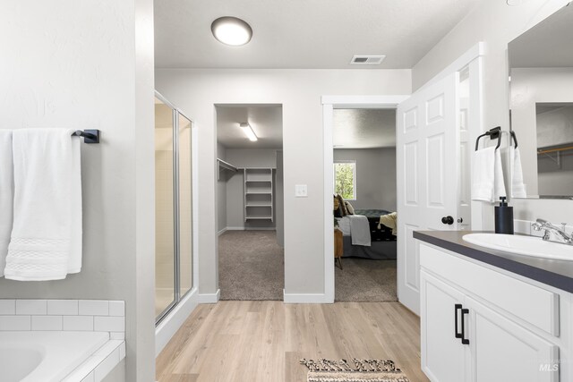 19920 Lenape Ct, Caldwell, ID 83605 - bathroom featuring wood finished floors, a shower stall, vanity, and a walk in closet