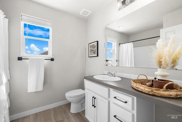 19920 Lenape Ct, Caldwell, ID 83605 - bathroom featuring vanity, toilet, wood finished floors, and baseboards