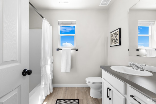 19920 Lenape Ct, Caldwell, ID 83605 - bathroom with vanity, toilet, wood finished floors, baseboards, and shower / bath combo with shower curtain