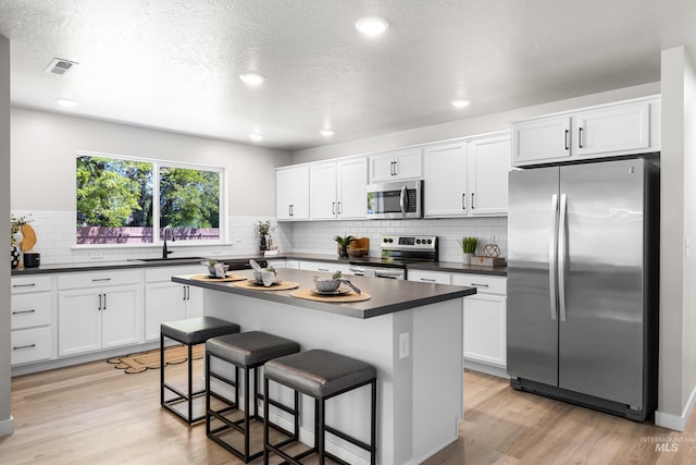 19920 Lenape Ct, Caldwell, ID 83605 - kitchen with appliances with stainless steel finishes, dark countertops, a sink, light wood-style floors, and recessed lighting