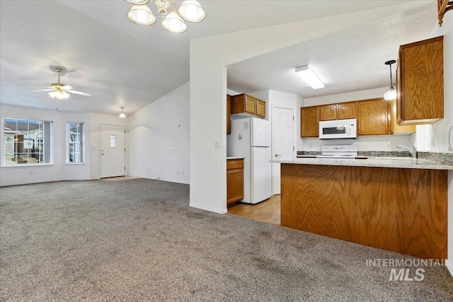 kitchen featuring decorative light fixtures, vaulted ceiling, light colored carpet, kitchen peninsula, and white appliances