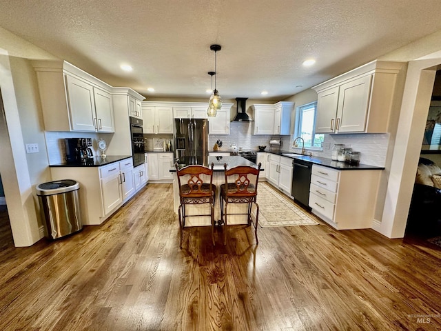 3195 N 3526e, Kimberly, ID 83341 - kitchen featuring black appliances, wall chimney exhaust hood, a sink, wood finished floors, and a textured ceiling