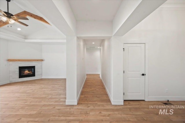 hallway with vaulted ceiling and light wood-type flooring