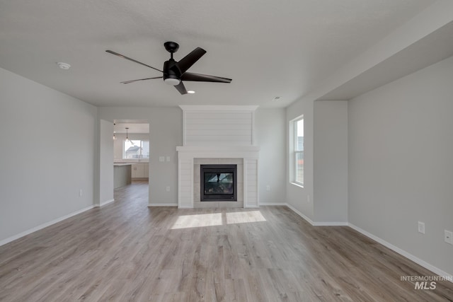 16888 Dunning Way, Caldwell, ID 83607 - unfurnished living room with a ceiling fan, light wood-style flooring, a large fireplace, and plenty of natural light