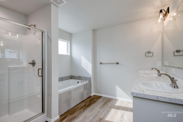 16888 Dunning Way, Caldwell, ID 83607 - full bathroom with a bath, wood finished floors, a stall shower, and a sink