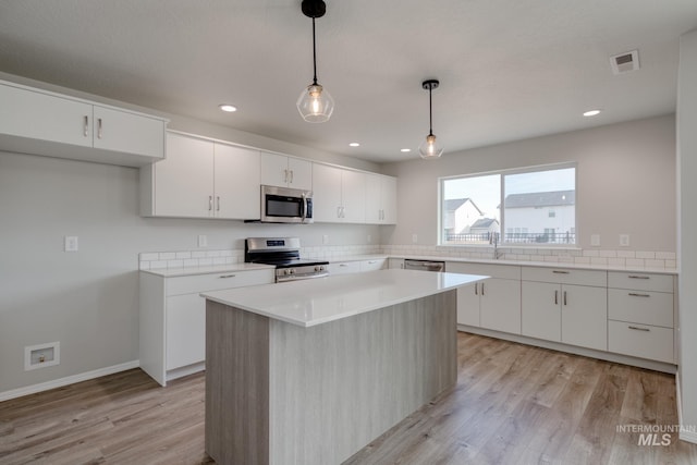 16888 Dunning Way, Caldwell, ID 83607 - kitchen featuring light countertops, light wood-type flooring, white cabinetry, and stainless steel appliances