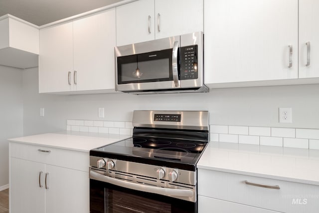 16888 Dunning Way, Caldwell, ID 83607 - kitchen featuring light countertops, tasteful backsplash, appliances with stainless steel finishes, and white cabinets