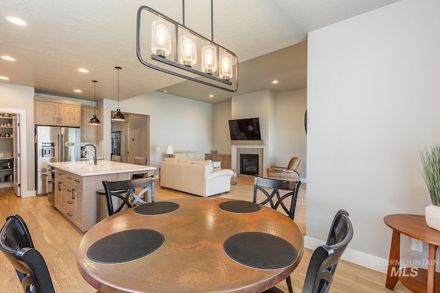 11706 W Lilium St, Star, ID 83669 - dining area with light wood-type flooring, recessed lighting, and a glass covered fireplace