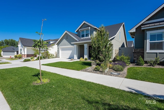 11706 W Lilium St, Star, ID 83669 - view of front facade with concrete driveway, board and batten siding, a front lawn, stone siding, and a garage