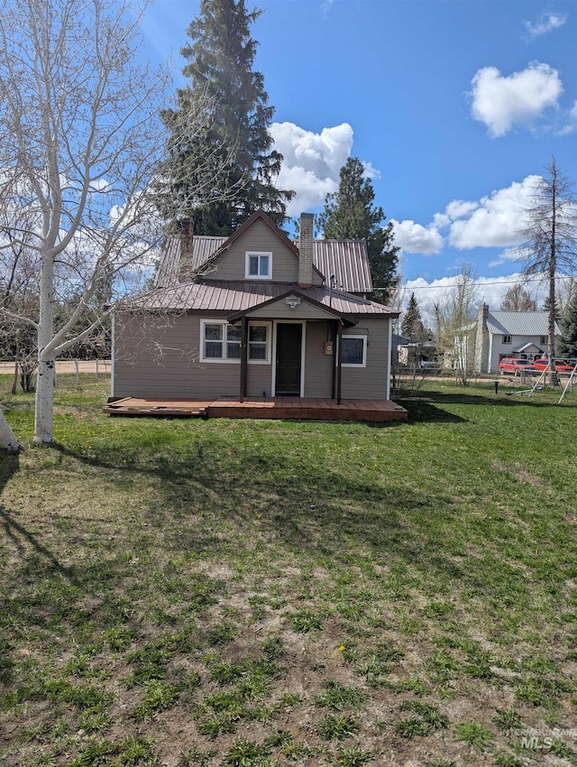 231 Willow Ave E, Fairfield, ID 83327 - view of front of house with fence, a front yard, a chimney, and metal roof