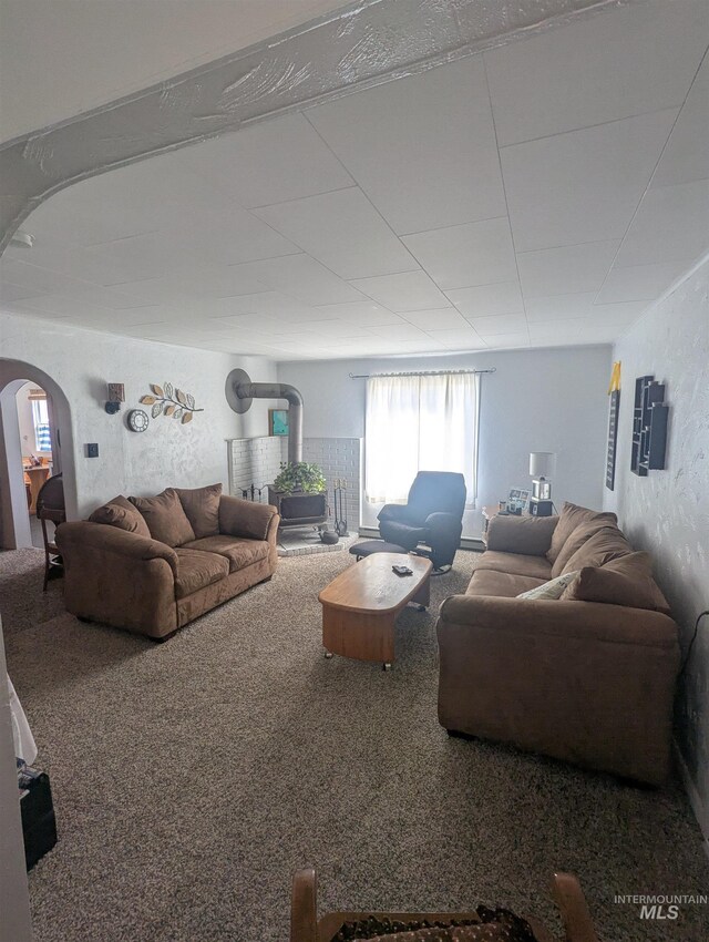 231 Willow Ave E, Fairfield, ID 83327 - carpeted living area featuring arched walkways and a wood stove